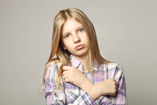 Close up portrait of beautiful teenager girl with sad depressed facial expression. Pretty young woman with long blonde hair looking stressed and worried. isolated background, copy space. - 写真・画像