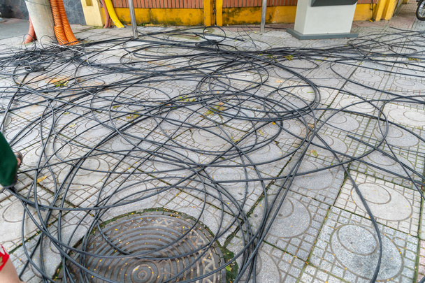Шнур питания и кабель питания запутанные на дорожке, пол и круг дренажный шланг
. - Фото, изображение
