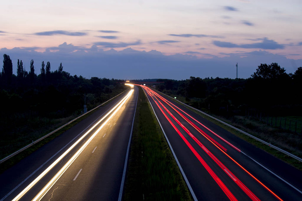 Hungarian highway at night showing vehicles lights, low shutter speed, top view, sky background. - Photo, image