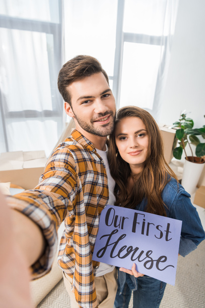kameran näkökulmasta hymyilevä pari meidän ensimmäinen talon kortti ottaa selfie yhdessä uudessa kodissa
 - Valokuva, kuva