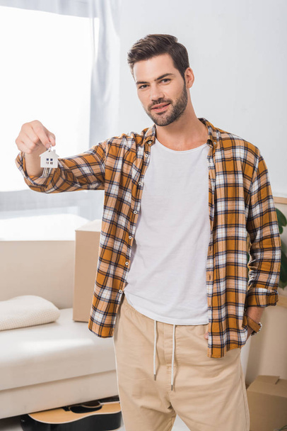 portrait of young man showing keys from new house in hand - Photo, Image