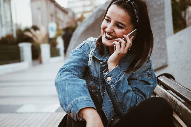 Крута і красива молода жінка розмовляє по телефону в місті. Міський стиль
 - Фото, зображення