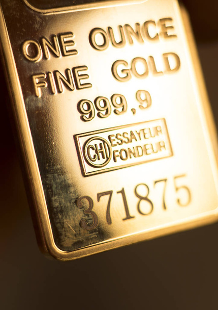Fine solid gold 999.9 one ounce bullion ingot precious metals bar closeup isolated photo. - Photo, Image
