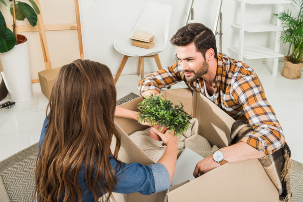 partial view of young couple unpacking cardboard boxes together at new home, moving home concept - Photo, Image