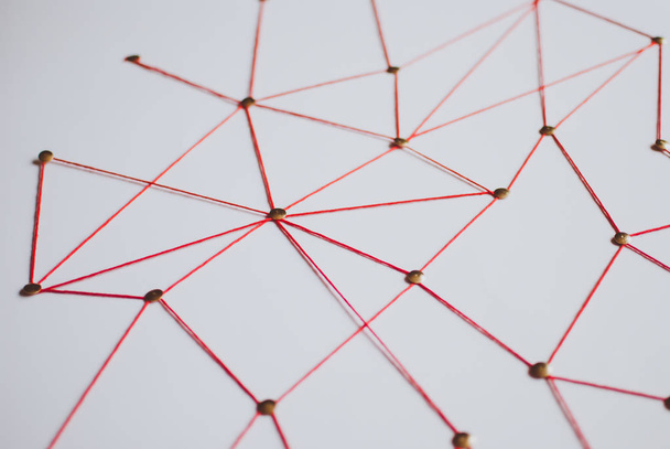 Achtergrond. Abstract concept (idee) van netwerk, sociale media, internet, teamwork, communicatie. Thumbtacks met elkaar verbonden door de rode draad. Geïsoleerd. Entiteiten aangesloten. - Foto, afbeelding