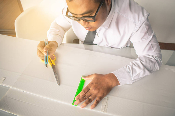 Homme asiatique découpant du papier avec des ciseaux pour l'artisanat papier et créer  - Photo, image