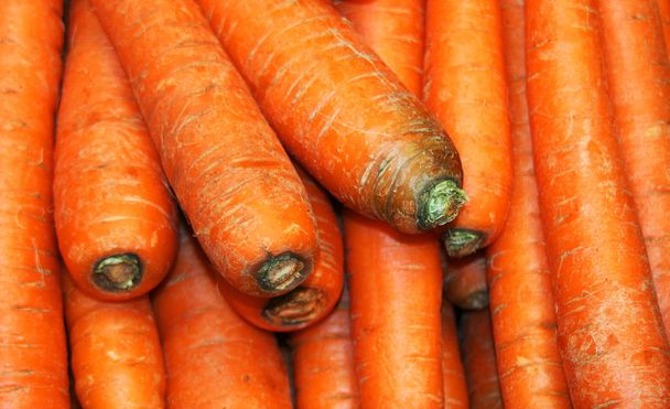 Grupo de zanahorias en el supermercado. Las zanahorias son una forma domesticada de la zanahoria silvestre, Daucus carota, nativa de Europa y el suroeste de Asia, originaria de Persia y fue cultivada por sus hojas, semillas
 - Foto, Imagen