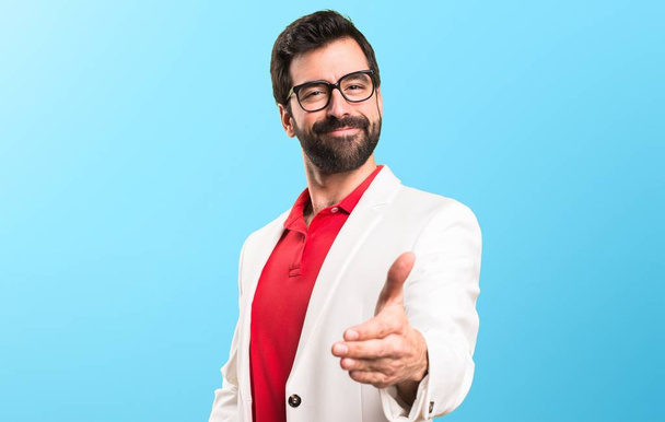 brünetter Mann mit Brille macht einen Deal auf buntem Hintergrund - Foto, Bild