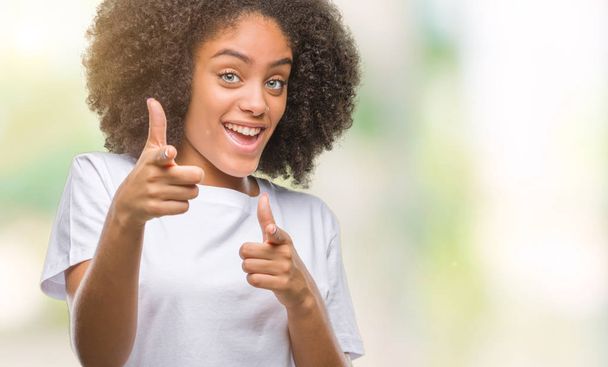 Young afro american woman over isolated background pointing fingers to camera with happy and funny face. Good energy and vibes. - Foto, Imagen