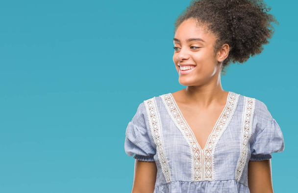 Young afro american woman over isolated background looking away to side with smile on face, natural expression. Laughing confident. - Foto, Bild