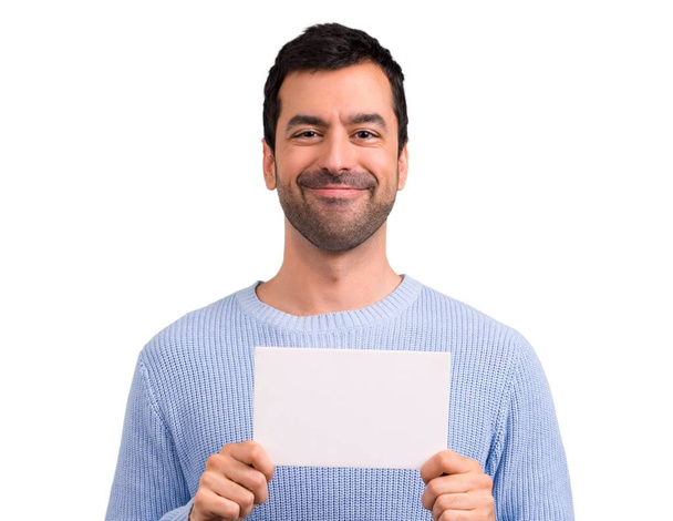 Hombre con suéter azul sosteniendo un cartel blanco vacío para insertar un concepto
 - Foto, imagen