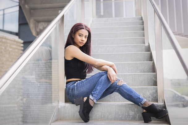 Girl sitting on a stairs with fashion pose - Foto, Imagen