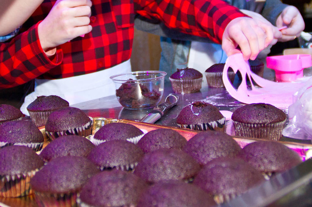 Koken cupcakes in de vorm. Mens de hand en deeg in papieren vorm voor cupcakes. Voorbereiding van zelfgemaakte muffins voor Pasen. Selectieve aandacht. Close-up. - Foto, afbeelding