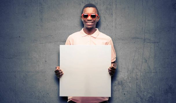 Afrikanischer schwarzer Mann mit Sonnenbrille und leerem Werbebanner, gutes Plakat für Werbung, Angebot oder Ankündigung, große Papierwerbetafel - Foto, Bild