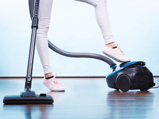 Household cleaning tools and devices, housekeeping duties concept. Woman legs and vacuum cleaner - Valokuva, kuva