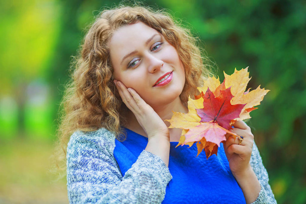 beautiful young plussize model with long curly hair in the autumn park - Zdjęcie, obraz