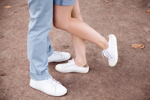 公園でハグするロマンチックなカップルの足のクローズ アップ - 写真・画像