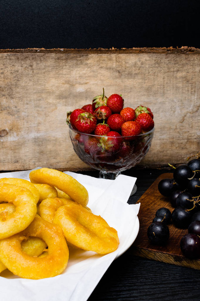 anneaux de calmar frits panés à la fraise, raisin sur fond de bois
 - Photo, image