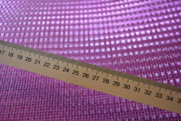 helles mathematisches Lineal aus Holz auf rosa reflektierendem Hintergrund. - Foto, Bild
