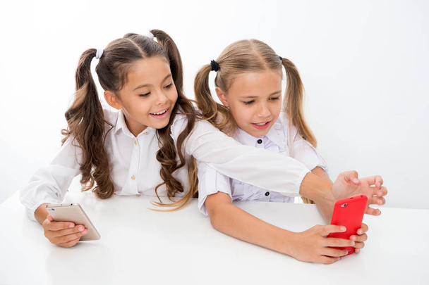 school break for happy little girls using smartphones. little girls using smartphones on school break having fun. - Foto, Imagem