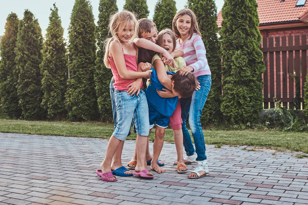 Gruppe fröhlicher kleiner Freunde amüsiert sich im Hinterhof. - Foto, Bild