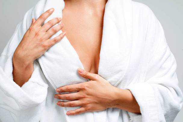 Body care concept. Beautiful woman after bath in white bathrobe on gray background. - Foto, immagini