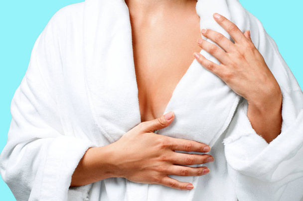 Body care concept. Beautiful woman after bath in white bathrobe on blue background. - Foto, imagen