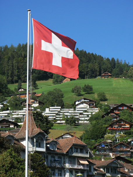 Sveitsin lippu vastaan Alppimökit
 - Valokuva, kuva