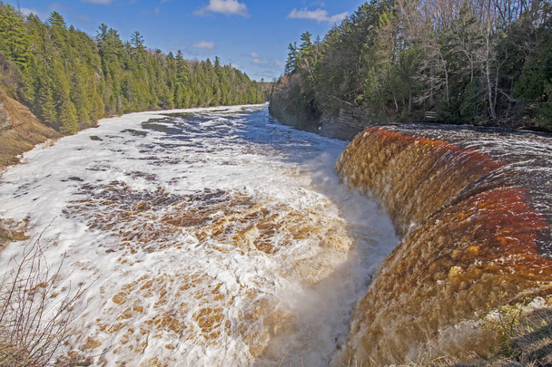 Aguas apresuradas sobre las cataratas del Alto Tahquamenon inundadas en el Parque Estatal Tahquamenon Falls en Upper Michigan
 - Foto, Imagen
