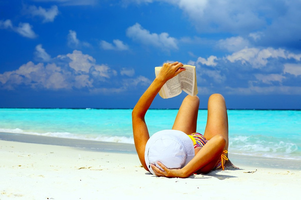 Young women is reading on the coral beach - Foto, imagen