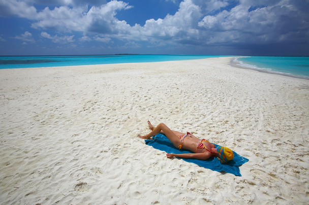 jonge vrouwen aan het zandstrand is sunburning - Foto, afbeelding