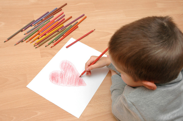 Criança atrai coração no papel
 - Foto, Imagem