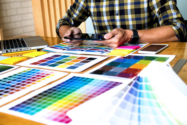 グラフィックデザイナーは、デザインのアイデアのためのカラーバーの例から色を選択するためにタブレットを使用して、グラフィックデザイナーのコンセプトの創造的なデザイン. - 写真・画像