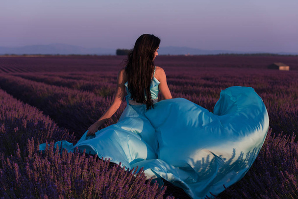 lavander flower field woman in cyand dress having fun and relax on wind in  purple flower field - Photo, image