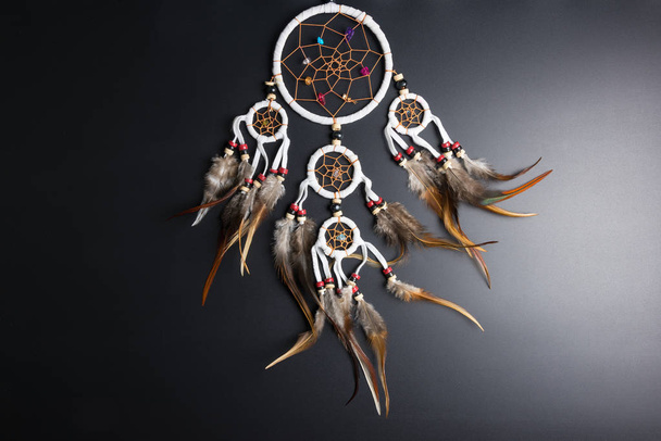Dream catcher with feathers threads and beads rope hanging spiritual folk american native indian amulet isolated on black background.Copy space for text.Concept prevent evil in Halloween - Photo, Image