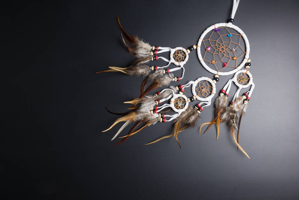 Dream catcher with feathers threads and beads rope hanging spiritual folk american native indian amulet isolated on black background.Copy space for text.Concept prevent evil in Halloween - Фото, зображення