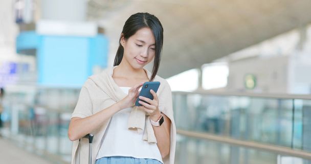 Nő a repülőtéren a mobiltelefon használata - Fotó, kép