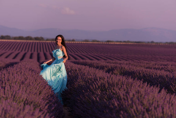 lavander flower field woman in cyand dress having fun and relax on wind in  purple flower field - 写真・画像
