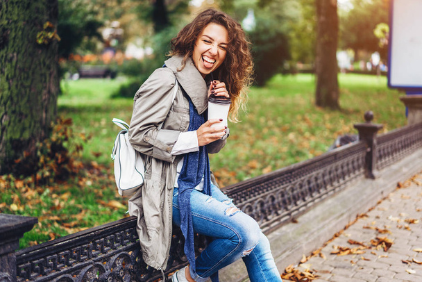 girl with curly hair holding coffee cup and laughing - 写真・画像
