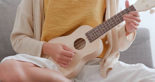 Femme jouant la chanson avec ukulele à la maison
 - Photo, image