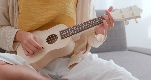 Nő gyakorlatok ukulele otthon - Fotó, kép