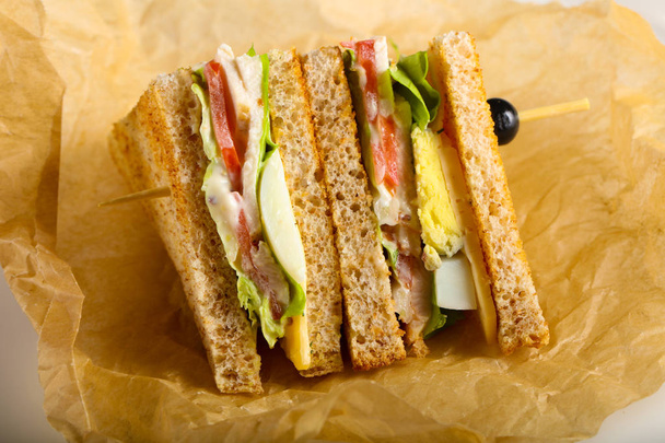 Sándwich club con carne, queso y verduras
 - Foto, Imagen