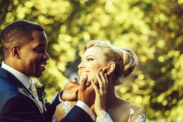 Loving groom touches face of adorable bride - Fotografie, Obrázek