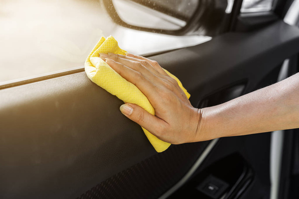 hand with microfiber cloth cleaning interior car door panel - Foto, Imagen