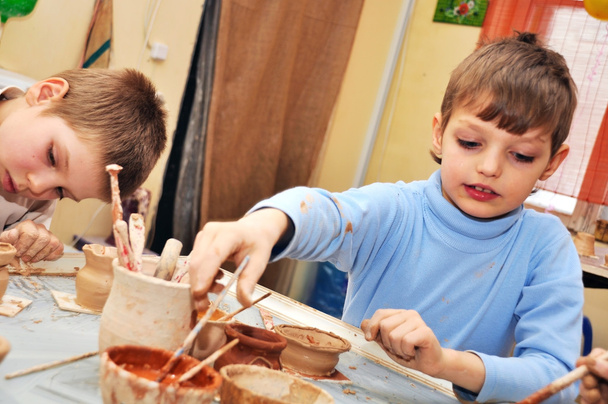 children shaping clay in pottery studio - 写真・画像