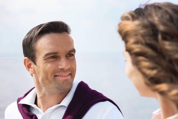 portrait of smiling couple looking at each other with blue sky on background - Photo, Image