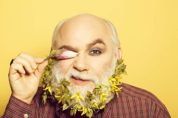 old man with flowers and leaves in beard - Фото, изображение