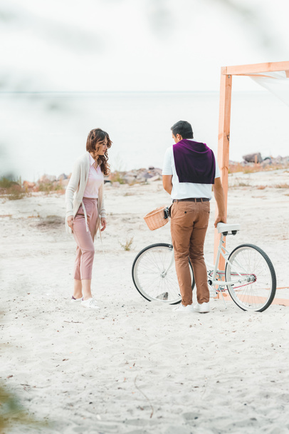 couple with retro bicycle on sandy beach - Photo, Image