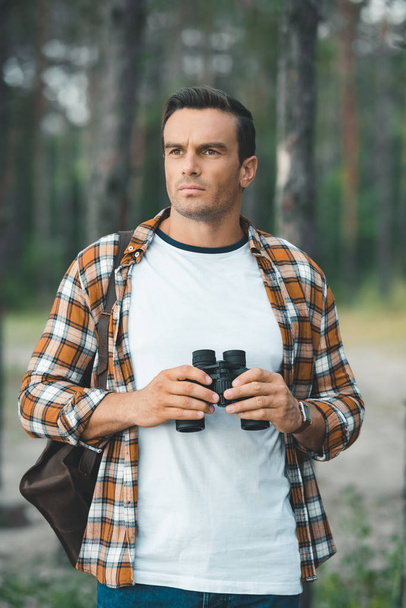 retrato de turista pensativo com binóculos na floresta
 - Foto, Imagem