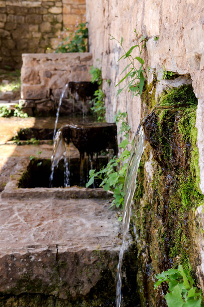 Une source de pierre close-up avec de l'eau froide et claire dans les montagnes par une journée d'été ensoleillée (région de Tzoumerka, Grèce, montagnes Pindos
). - Photo, image